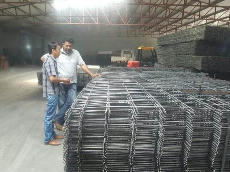 Horizon Metal team inspecting finished welded mesh panels with a customer